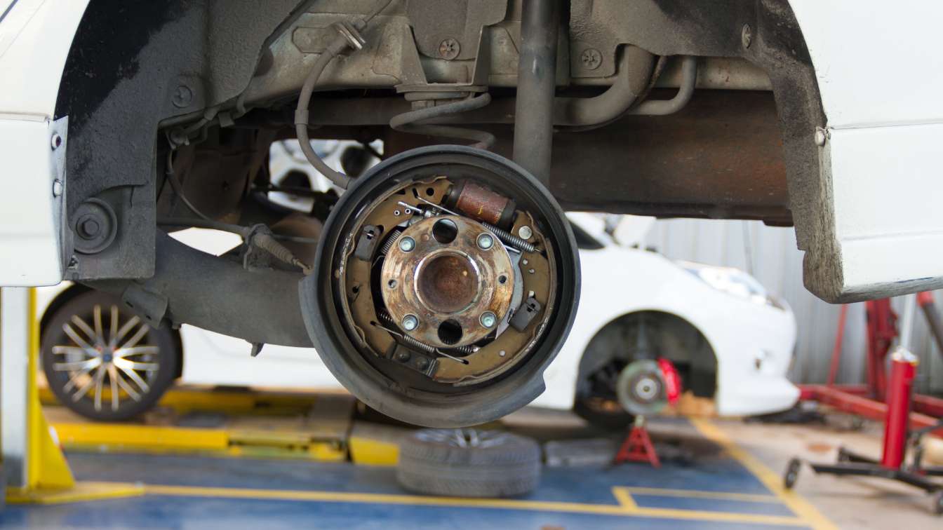 Vehicle on a lift with the rear brake assembly exposed during service