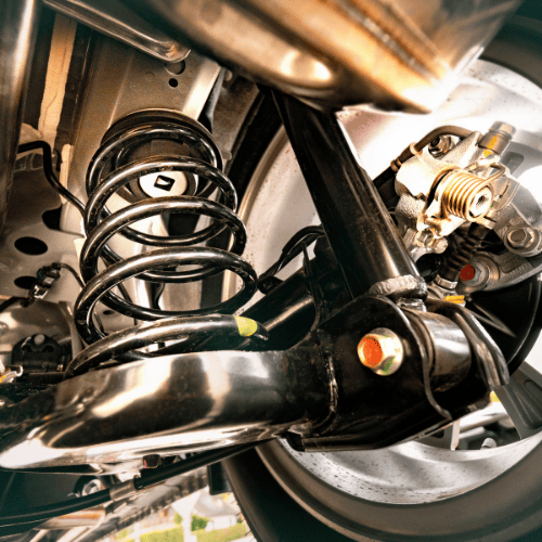 Close-up view of a car's suspension system, showcasing the coil spring, shock absorber, and brake components.